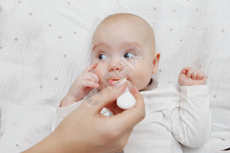 美丽的五个月可爱的女婴用勺子吃饭健康的食物产妇护理儿童保育图片