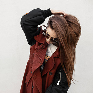 时髦的现代年轻时髦女人在时髦的风衣时髦的太阳镜拉直户外的头发图片