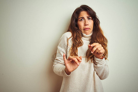 年轻漂亮的女人穿着冬天的毛衣站在白色孤立的背景上厌恶的表情图片