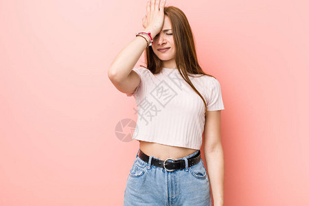 红发年轻姜女人对着粉红色的墙壁忘记了什么东西用手掌扇额图片