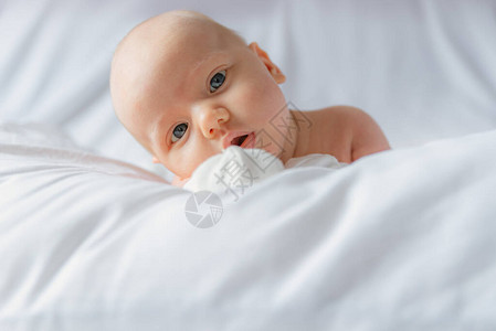 躺在床上的情感婴儿在玩瞪着眼看的图片