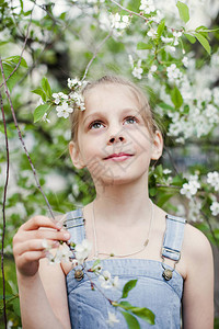 春天盛开的花园中金发少女的画像图片