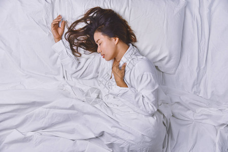 睡在床上的少妇躺在床上睡得很好的年轻女子的顶视图睡觉放松图片