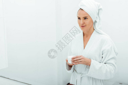 穿着浴袍和毛巾的漂亮女人把容器装图片