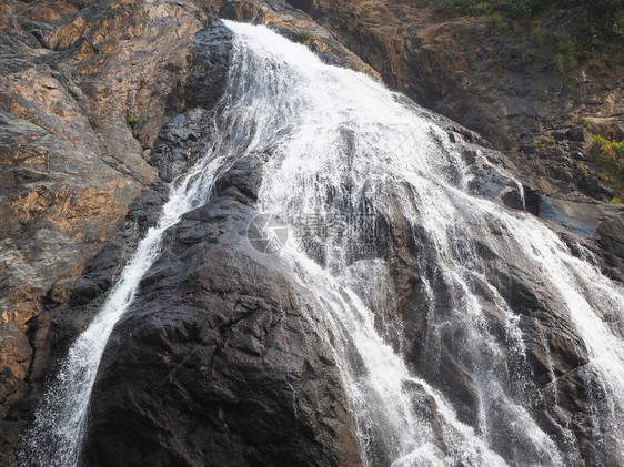 环绕岩石的流水和坠落山崩在地表上下图片