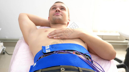 特写腹部肌肉的电刺激程序一个人被动地刺激腹部肌肉图片