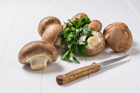 一把带木柄的刀和白色桌子上的一些皇家蘑菇素食人图片