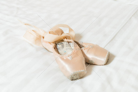白床上的足尖芭蕾舞鞋图片