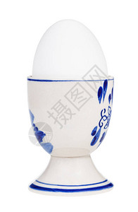 陶瓷鸡蛋杯中白煮蛋的侧面视图图片