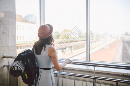 旅行者后视女站在大厅火车站的窗户前图片