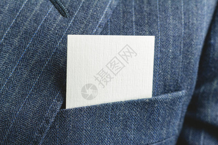 蓝色西装外套口袋里的白色空白名片特写图片