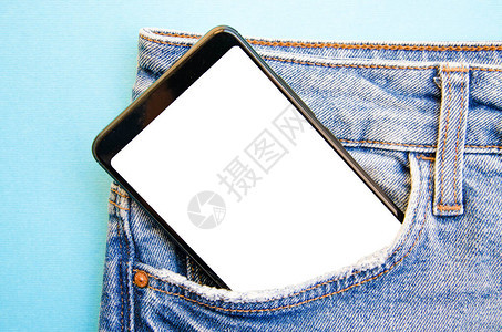 牛仔裤口袋里的白屏智能手机文本的智能手机地方蓝色背景上口袋里的智能手图片