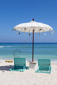 白沙滩雨伞和绿色遮阳床图片