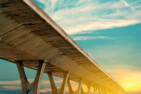 高架混凝土公路的底视图立交水泥路道路立交桥结构与日出天空的现代高速公路混凝土桥梁工程施图片