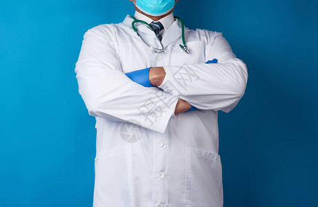 穿着白色医疗大衣和蓝色乳胶手套的医生站在蓝背景上图片