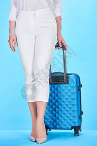 女持有蓝色彩旅行袋的手柄的部分外图片