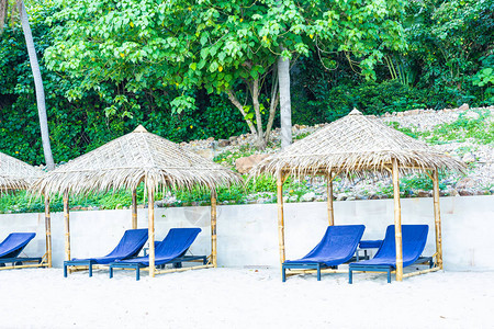 热带海滩和洋的伞和椅子为假日图片