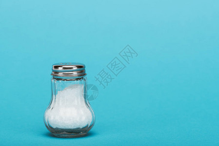 充满盐的玻璃盐含蓝色背景盐背景图片