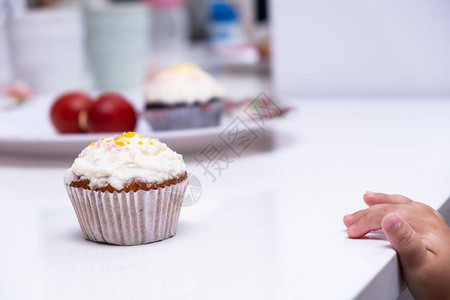 孩子们的手伸去拿蛋糕蛋糕白色桌子上的杯形蛋背景图片