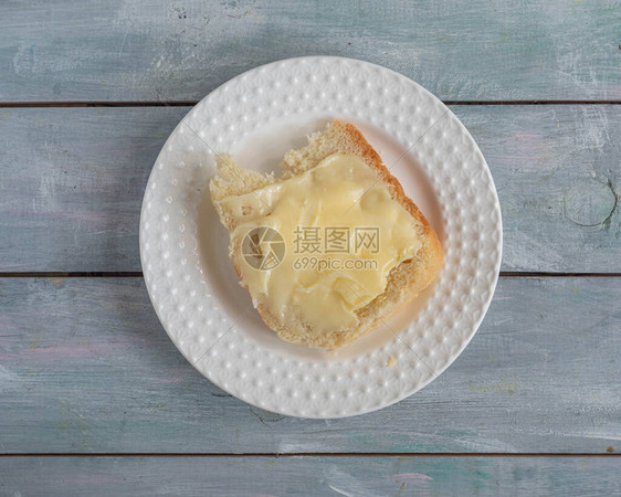 大三明治白面包上放黄油和蜂蜜木盘上放图片