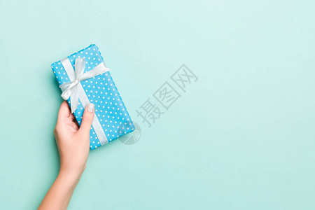 女人的手用彩色纸给包装好的圣诞节或其他节日手工礼物图片