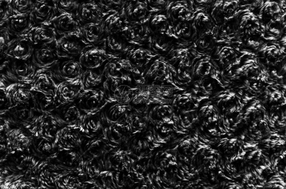 黑色羊毛质地背景棉绒深色天然羊毛黑色蓬松毛皮碎片灰色地毯带编织图案细节的特写灰色羊毛带有扭曲的图片