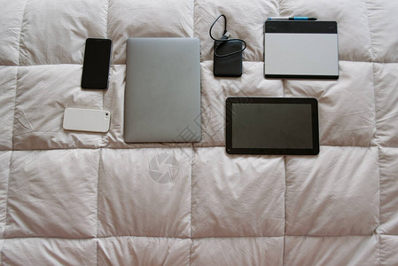 自由职业者在床上订购设备手机手机外置磁盘绘图板电脑记事本笔记本耳图片