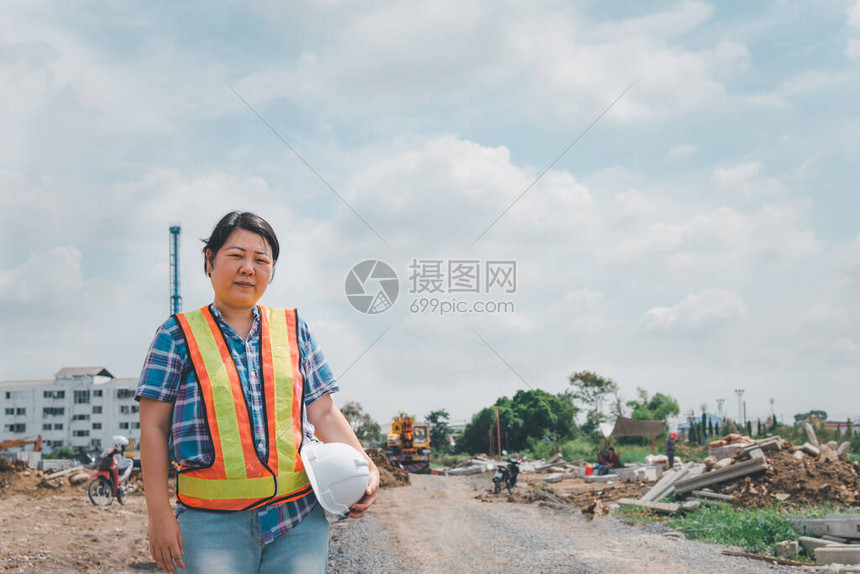 戴着头盔和安全背心的亚洲女土木建筑工程师或建筑师在建筑或建筑工图片