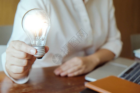 创意学习桌面拥有灯泡概念创意和灯泡的商界人士背景