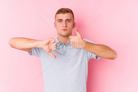 年轻的caucasian年轻男子孤立地显示拇指向上和拇指向下图片