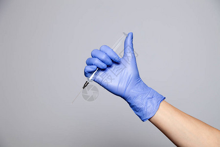 特写医生的手在橡胶紫色手套拿着没有盖帽的透明注射器在白色背景上隔离拒绝接种疫苗疫苗接种狂犬图片