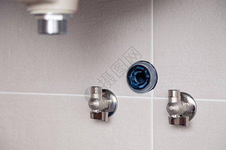 特写aquastop阀门插座切口分支在瓷砖墙上在带瓷砖墙的浴室中固定水槽专业管道维修图片