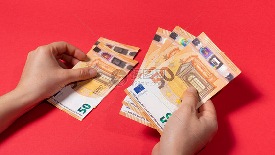 该男子在红色背景虑钞票50欧元的金额信用货图片