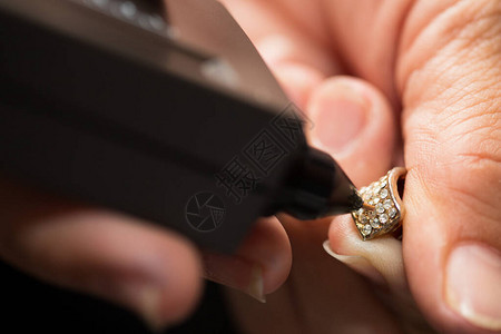 手中的金戒指准备好用钻石测试仪宝石选择器宝石LED指示灯珠宝套件测试检查真假背景图片