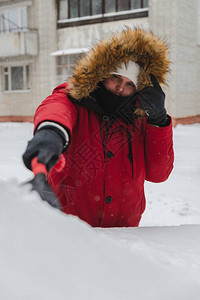 男子身穿红色冬大衣在雪风暴过后冬季用图片