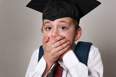 男孩戴着学生帽子白人背景中学毕业证书和初中毕业证书图片
