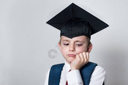 穿着学生帽子的悲哀男孩用手砍头失败考试白图片