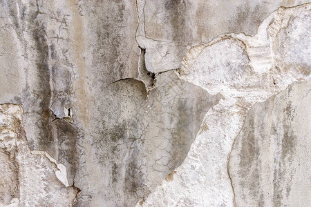 破旧墙壁的质地带有划痕裂缝和油漆剥落的孔洞的石头质地图片