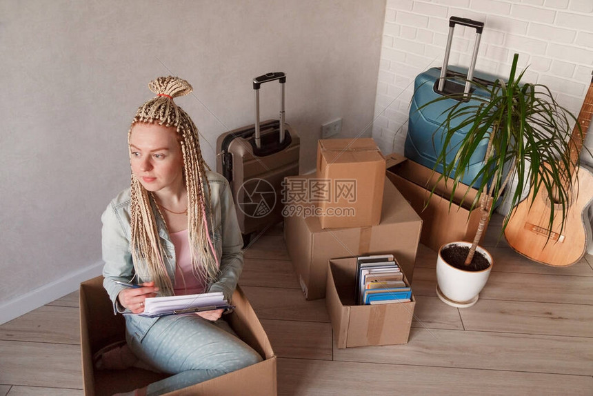 穿着散装坐在盒子里的漂亮女人把她的东西包装在箱子高清图片下载-正版图片504173228-摄图网