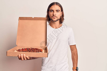 年轻英俊男子拿着送披萨盒的比萨饼盒思考态度和清醒的表情图片