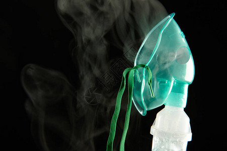 绿色塑料吸入器面罩封闭黑色背景隔离的图片
