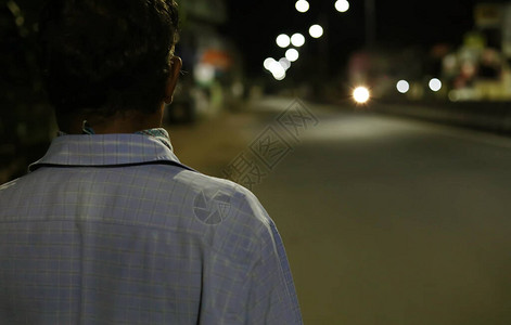 夜晚,孤单一个孤单的男人晚上在空荡背景