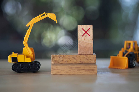 黄色玩具汽车挖掘机和木制立方体X消除不正确图片