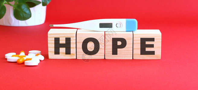 HOPE这个词是用红色的木块做的配有医药物的红色背图片