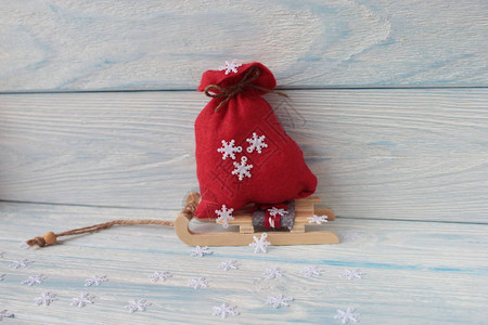 装着礼物的红色袋子站在木制雪橇上图片