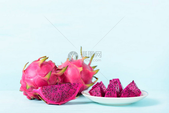 白盘上切红龙果和面粉背景图片