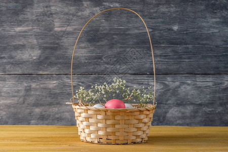 灰色木本底带明亮复活节鸡蛋的篮子图片