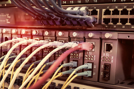 具有蓝色和红色互联网跳线电缆的服务器机架连接到数据服务器机房中图片
