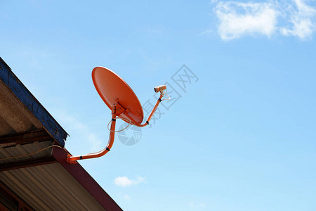用于接收电视信号的橙色卫星碟形天线安装在房屋的顶上图片