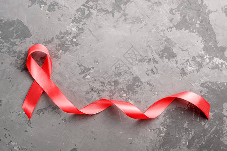 混凝土背景上的红丝带12月1日世界艾滋病日图片